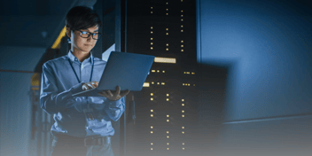 woman checking computer in a server room