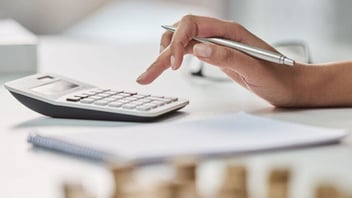 hand typing on calculator